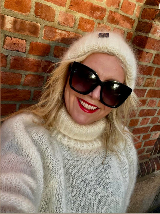 Linn Skåber med offwhite flettelue og genser