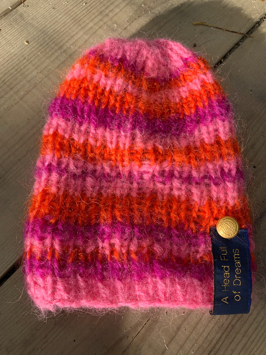 Håndstrikket stripet ribbelue i oransje og rosa mohair med heng bak – Striped Pink fra CosyMonday